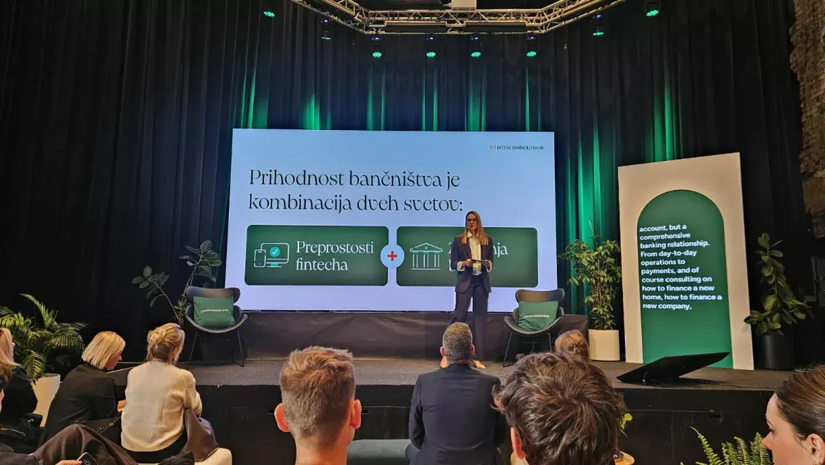 Govornica na odru pred zaslonom z napisom o prihodnosti bančništva in logotipom Intesa Sanpaolo Bank.